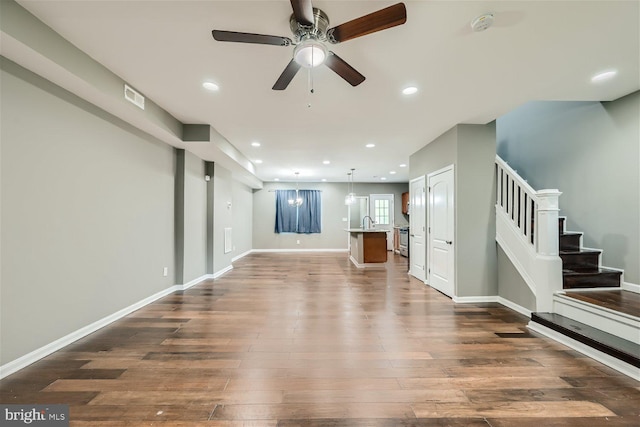 unfurnished living room featuring dark hardwood / wood-style floors, ceiling fan, and sink