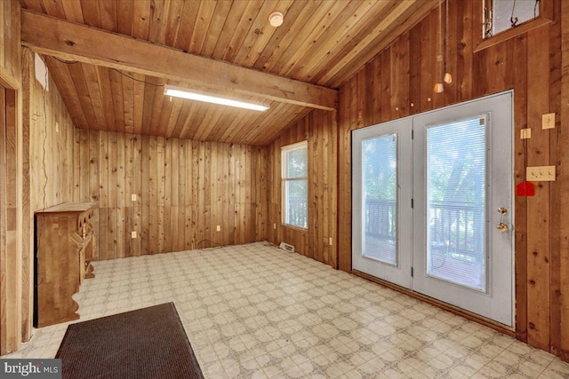 interior space with vaulted ceiling with beams, wood walls, and wooden ceiling