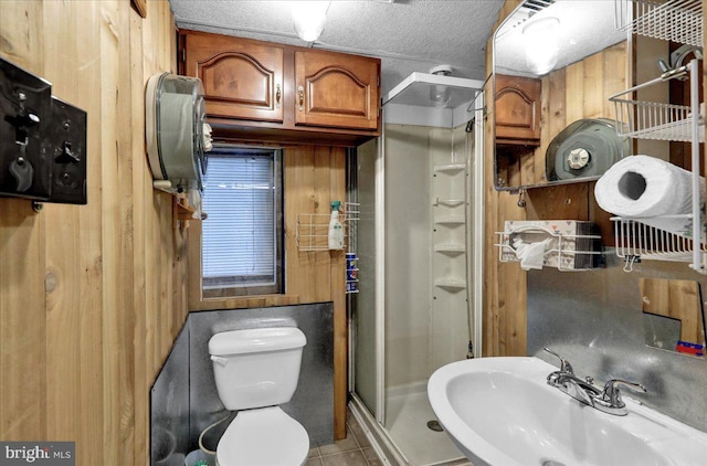 bathroom featuring tile patterned floors, an enclosed shower, a textured ceiling, sink, and toilet