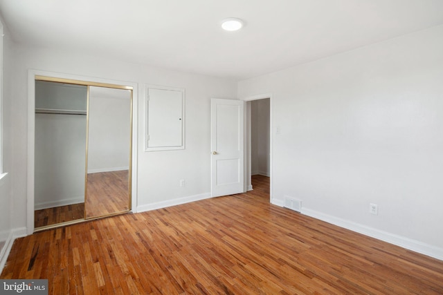 unfurnished bedroom featuring hardwood / wood-style flooring and a closet