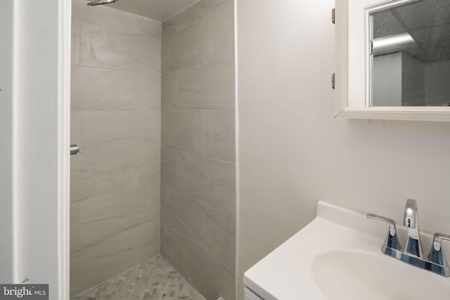 bathroom with vanity and tiled shower