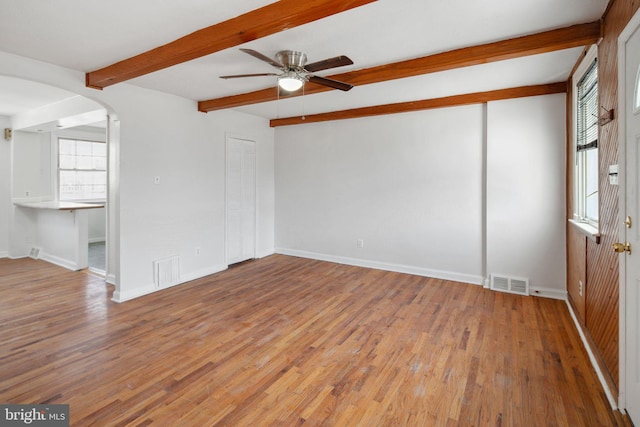 spare room featuring hardwood / wood-style flooring, ceiling fan, and beamed ceiling