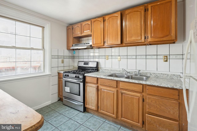 kitchen with backsplash, sink, light tile patterned floors, gas stove, and extractor fan