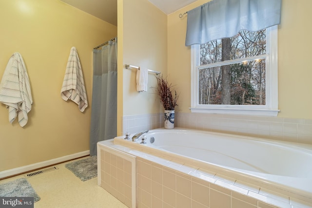 bathroom with independent shower and bath and a wealth of natural light