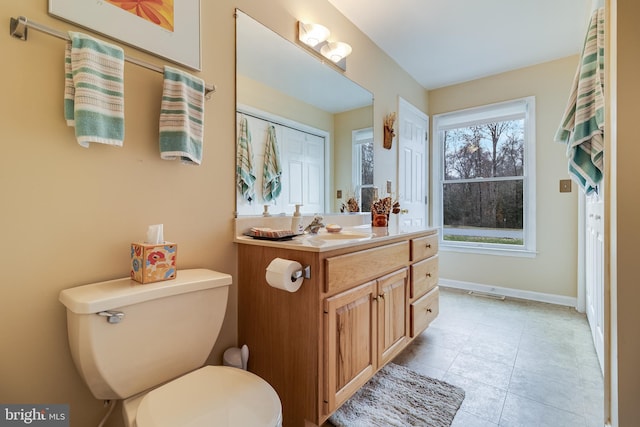 bathroom featuring tile patterned flooring, vanity, and toilet