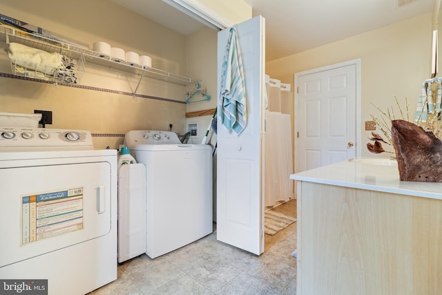 washroom with washing machine and dryer and light tile patterned floors