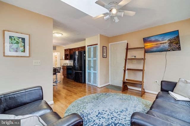 living room with ceiling fan and light hardwood / wood-style floors