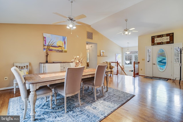 dining space with hardwood / wood-style floors, ceiling fan, and lofted ceiling