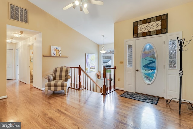 entrance foyer with ceiling fan, high vaulted ceiling, and wood-type flooring