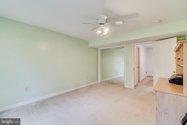 unfurnished bedroom with ceiling fan, a closet, and light carpet