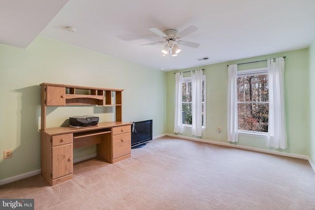 unfurnished office with ceiling fan and light colored carpet