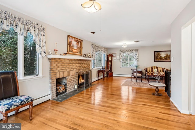 sitting room featuring a fireplace, light hardwood / wood-style floors, and a wealth of natural light