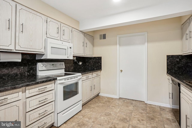 kitchen featuring backsplash, dark stone countertops, and white appliances