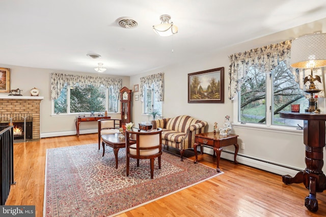 dining room featuring a fireplace, hardwood / wood-style flooring, and baseboard heating