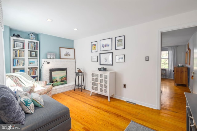 sitting room with a fireplace and wood-type flooring