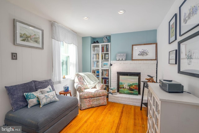 sitting room with a fireplace and hardwood / wood-style floors