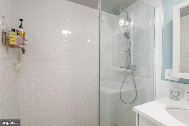 bathroom featuring tiled shower and vanity