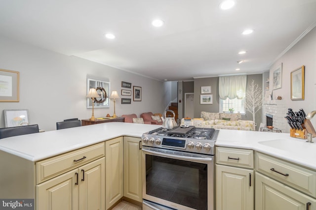 kitchen featuring crown molding, stainless steel range oven, kitchen peninsula, and a fireplace