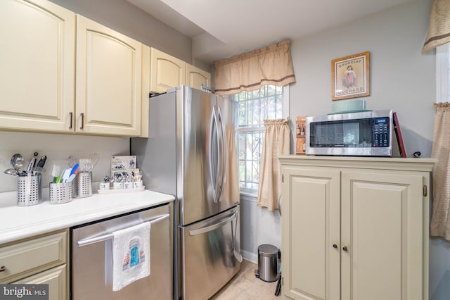 kitchen with light tile patterned floors and stainless steel appliances