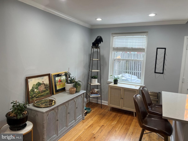 home office with crown molding and light wood-type flooring