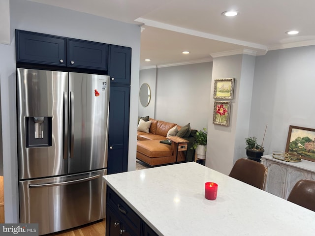 kitchen featuring blue cabinetry, stainless steel refrigerator with ice dispenser, a kitchen bar, and crown molding