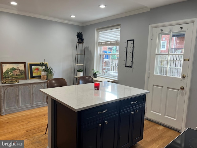 kitchen with crown molding, a center island, blue cabinets, and light hardwood / wood-style flooring