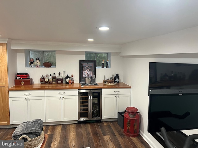 bar featuring wood counters, dark hardwood / wood-style floors, white cabinetry, and beverage cooler