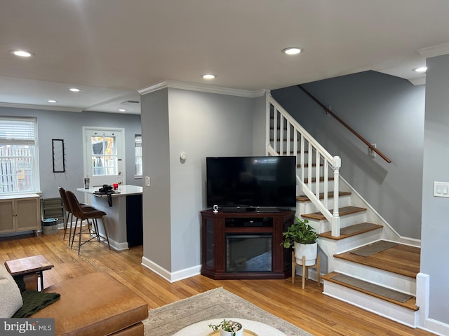 living room featuring light wood-type flooring and crown molding