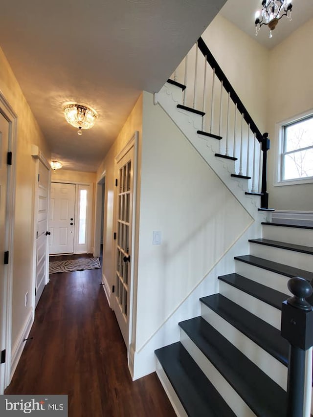 staircase featuring hardwood / wood-style floors and a notable chandelier