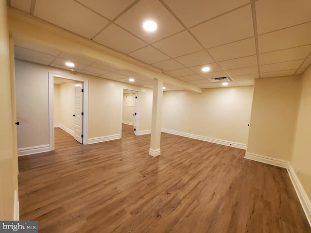 basement featuring hardwood / wood-style flooring and a drop ceiling