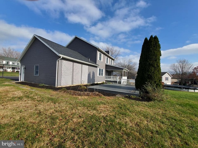 view of home's exterior featuring a lawn and a deck