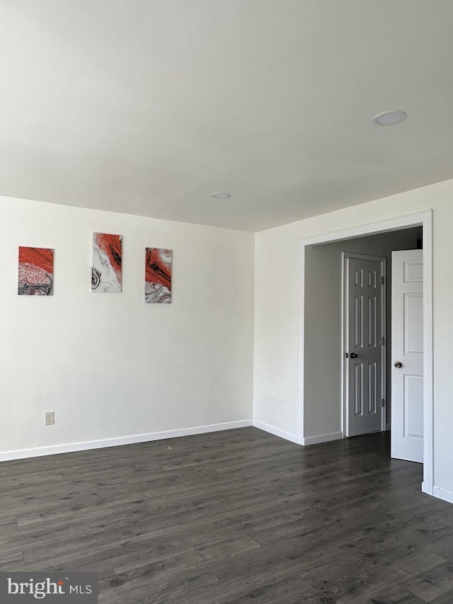 unfurnished room with dark wood-type flooring