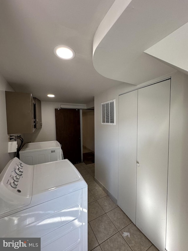 laundry room with washer and dryer and light tile patterned floors