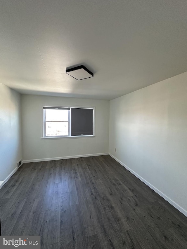 spare room with dark wood-type flooring