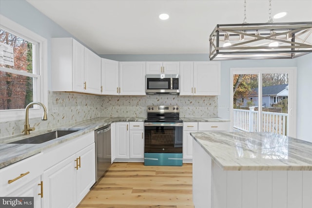 1356 College Rd, Dover, DE 19904 - kitchen with appliances with stainless steel finishes, a sink, light wood-type flooring, white cabinetry, and plenty of natural light