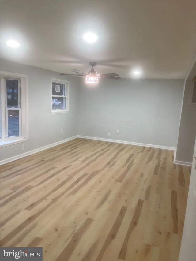 spare room featuring ceiling fan, light hardwood / wood-style floors, and a wealth of natural light