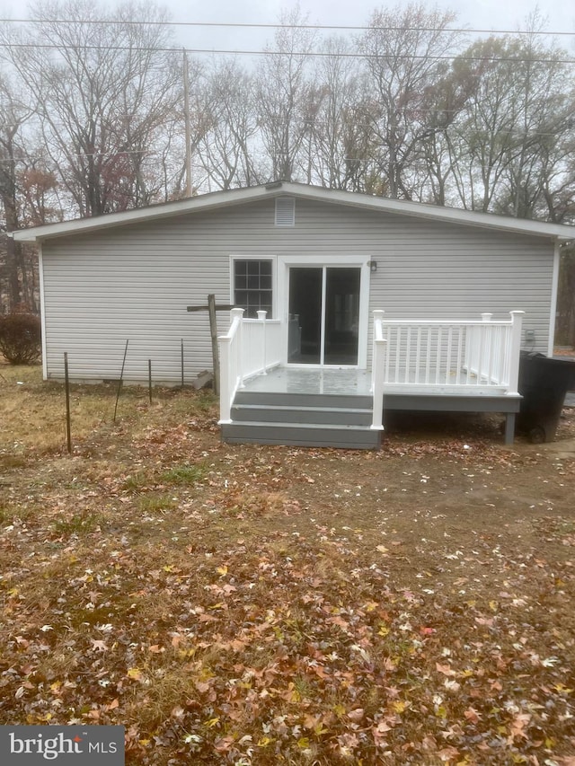 rear view of house featuring a wooden deck