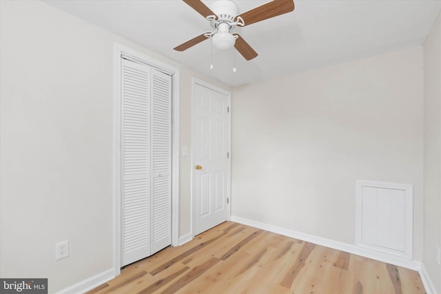 unfurnished bedroom featuring ceiling fan, a closet, and wood-type flooring