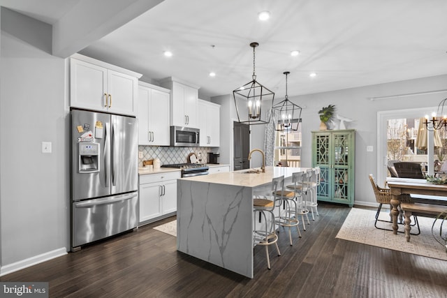 kitchen featuring a center island with sink, sink, dark hardwood / wood-style floors, white cabinetry, and stainless steel appliances