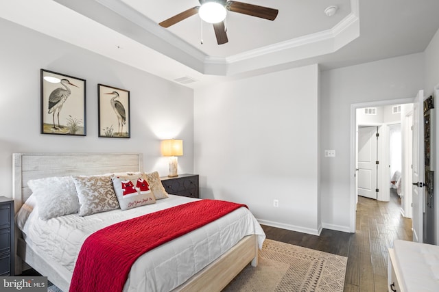 bedroom with dark hardwood / wood-style floors, a raised ceiling, ceiling fan, and crown molding