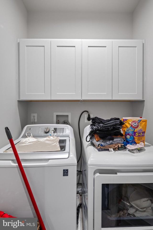 washroom with washing machine and dryer and cabinets