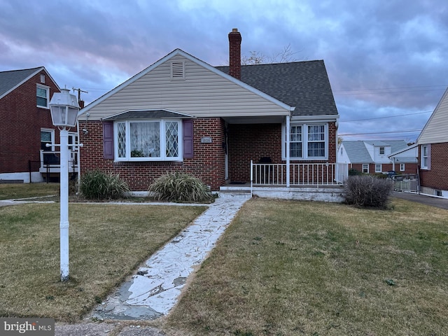 bungalow-style home featuring a porch and a front yard