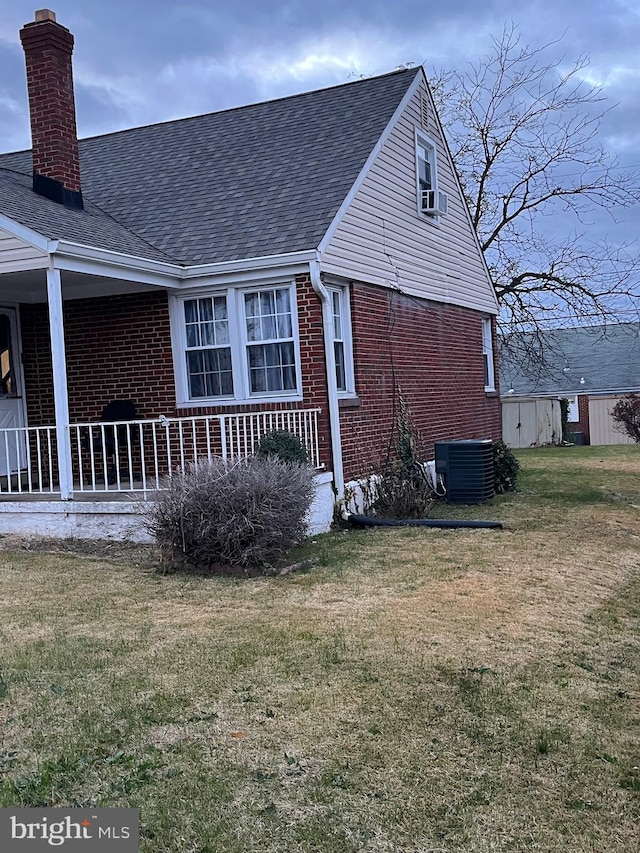 view of side of home featuring central air condition unit, a yard, and cooling unit