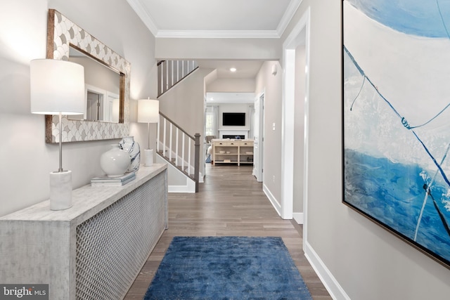 foyer entrance with ornamental molding and dark wood-type flooring