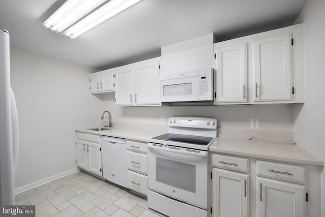 kitchen with light tile patterned floors, white appliances, white cabinetry, and sink