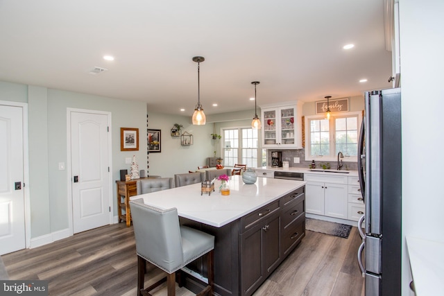 kitchen featuring a center island, sink, stainless steel appliances, dark hardwood / wood-style flooring, and white cabinets