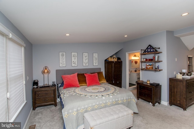 carpeted bedroom with vaulted ceiling and ensuite bath