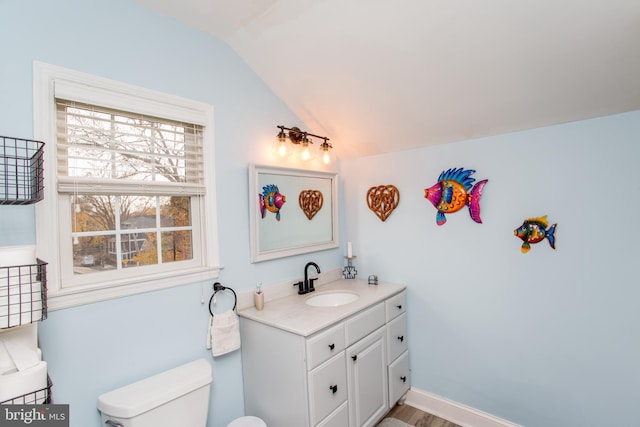 bathroom with hardwood / wood-style flooring, toilet, a wealth of natural light, and vaulted ceiling