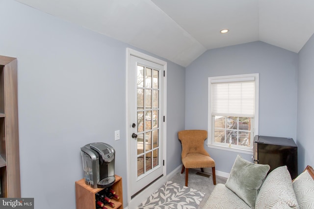 sitting room featuring light carpet, plenty of natural light, and lofted ceiling