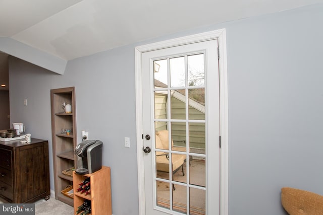 entryway with light colored carpet and lofted ceiling